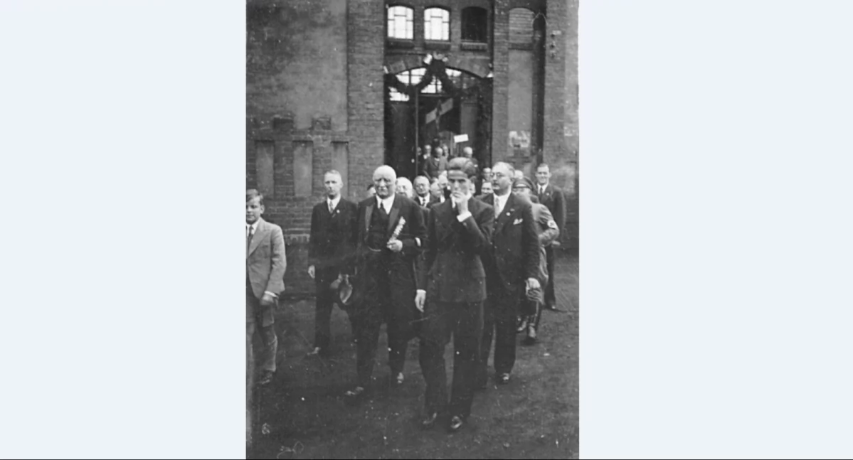 Adolf Deichsel, pośrodku zdjęcia, trzyma w ręku cylinder